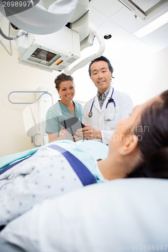 Image of Medical Team Looking At Patient On Xray Table