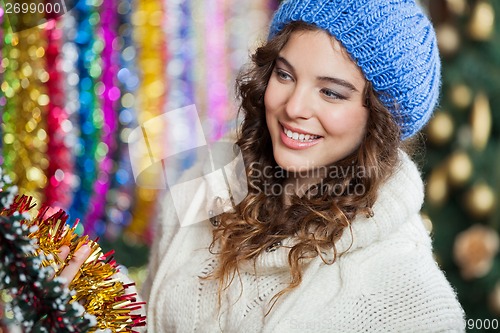 Image of Young Woman Choosing Tinsels At Store