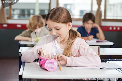 Image of Schoolgirl Searching In Pouch At Desk