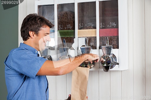 Image of Man Buying Coffee From Vending Machine In Supermarket