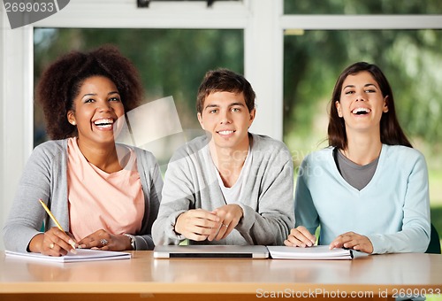 Image of Student With Friends Sitting At Desk In Classroom