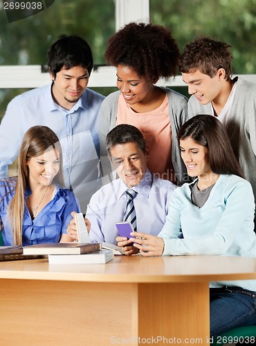 Image of Teacher And Students Discussing Over Mobilephone In Classroom