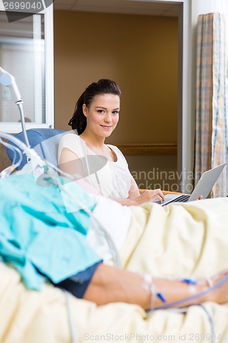 Image of Woman With Laptop Sitting By Male Patient