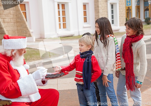 Image of Children Taking Biscuits From Santa Claus