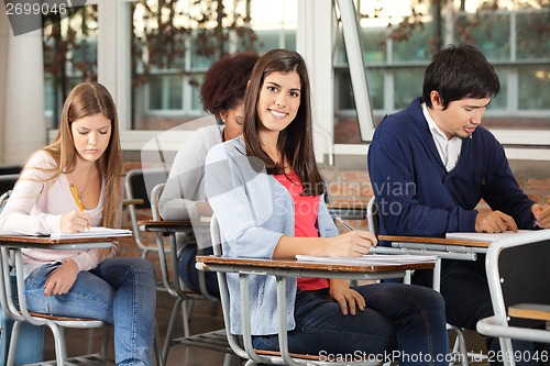 Image of Woman With Students Writing Exam In Classroom