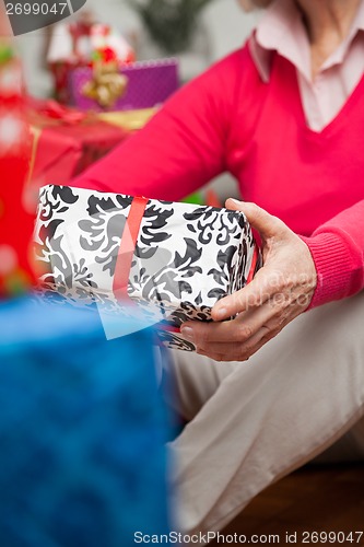 Image of Senior Woman Holding Christmas Gift