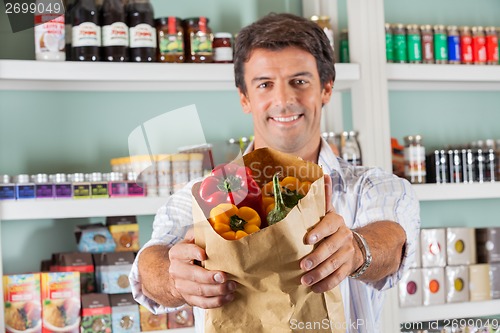 Image of Man Showing Fresh Bellpeppers In Paper Bag
