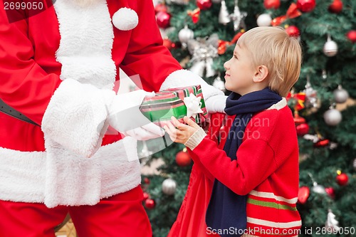 Image of Santa Claus Giving Gift To Boy