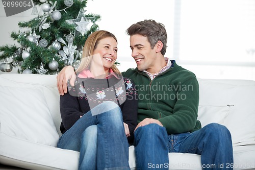 Image of Couple Relaxing On Sofa During Christmas