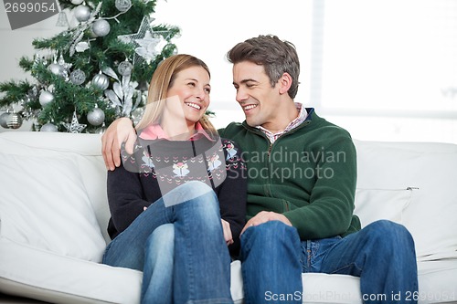 Image of Couple Relaxing On Sofa During Christmas