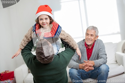 Image of Boy Being Carried By Father During Christmas