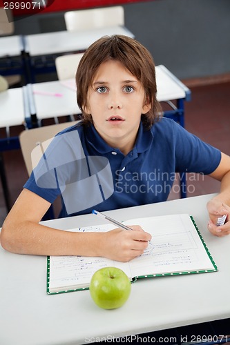 Image of Shocked Schoolboy With Cheat Sheet Sitting At Desk