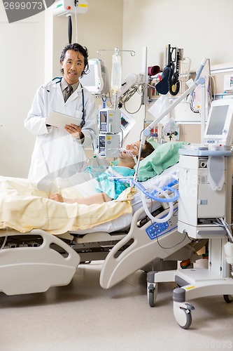 Image of Doctor With Digital Tablet Examining Patient's Report