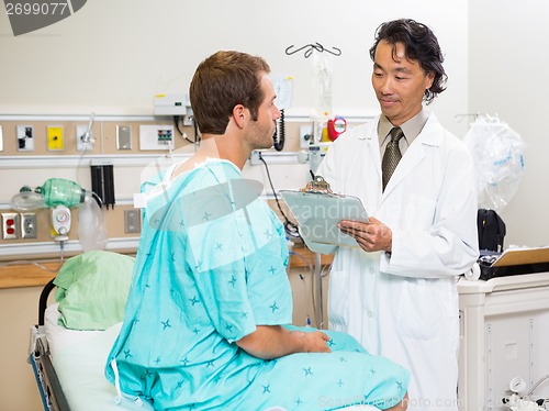 Image of Doctor Examining Patient's Report In Hospital