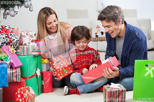 Image of Parents Giving Christmas Present To Son