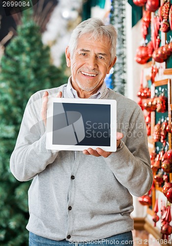 Image of Happy Man Displaying Digital Tablet In Christmas Store