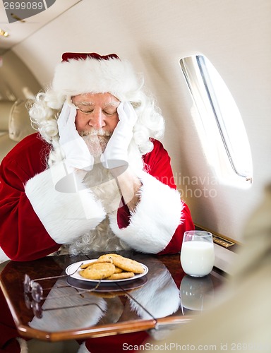 Image of Santa With Cookies And Milk Sleeping In Private Jet