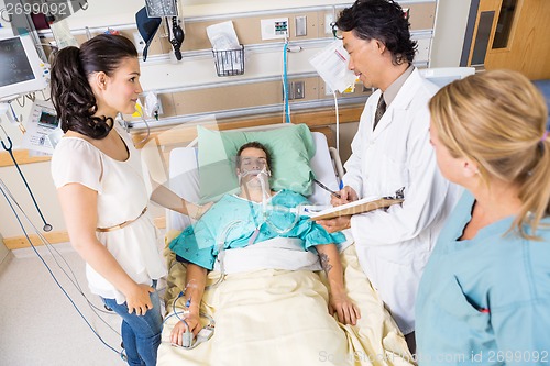 Image of Woman Looking At Doctor Examining Patient