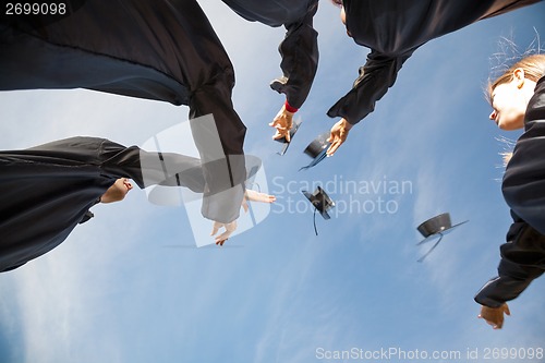 Image of Students Throwing Mortar Boards In Air On Graduation Day