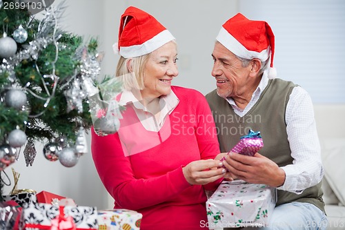 Image of Couple With Christmas Gifts Looking At Each Other