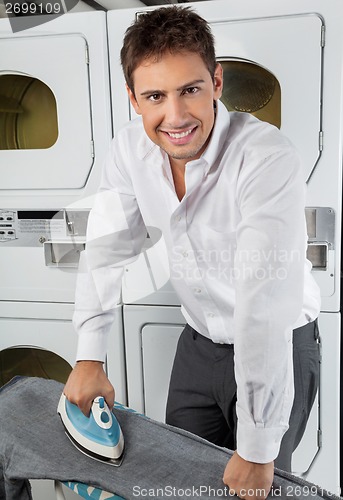 Image of Businessman Ironing Jeans In Laundry