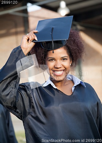 Image of Student In Graduation Gown Wearing Mortar Board On Campus