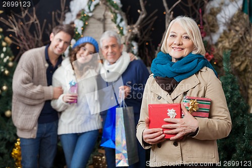 Image of Happy Family With Christmas Presents At Store