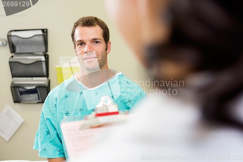 Image of Patient With Doctor In Foreground At Hospital