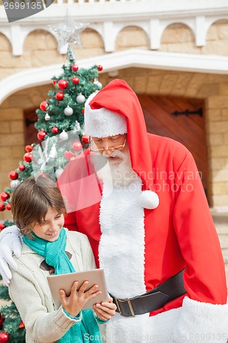 Image of Santa Claus And Boy Using Digital Tablet