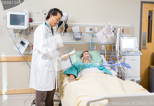 Image of Doctor With Clipboard Examining Patient's Report