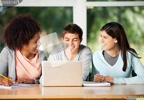 Image of Happy Friends With Laptop Sitting In Classroom