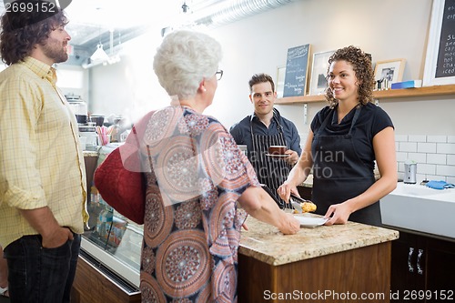 Image of Owner With Colleagues And Customers At Cafe Counter