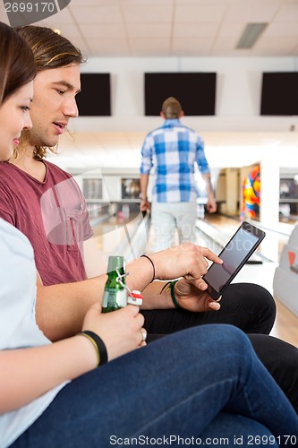 Image of Couple Using Digital Tablet in Bowling Club