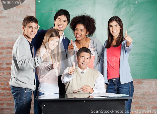 Image of Students And Professor Gesturing Thumbsup At Desk In Classroom