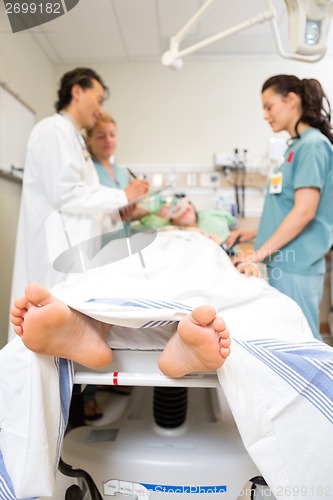 Image of Doctor And Nurses Examining Patient's Medical Report