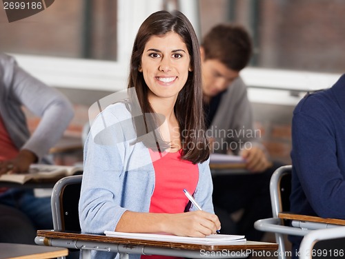 Image of Female Student Sitting At Desk In Classroom