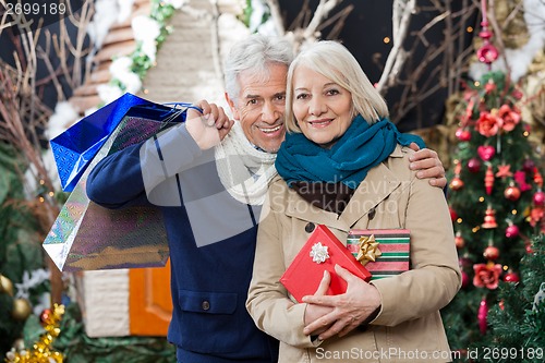 Image of Couple With Shopping Bags And Present At Christmas Store