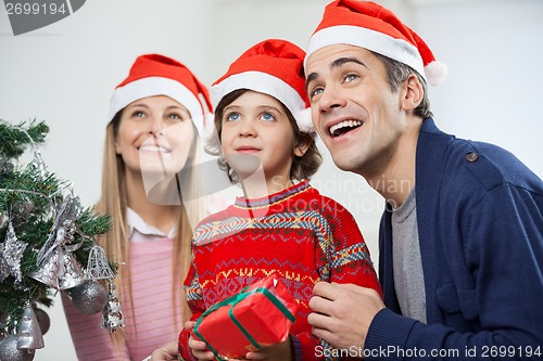 Image of Happy Family With Christmas Gift Looking Away