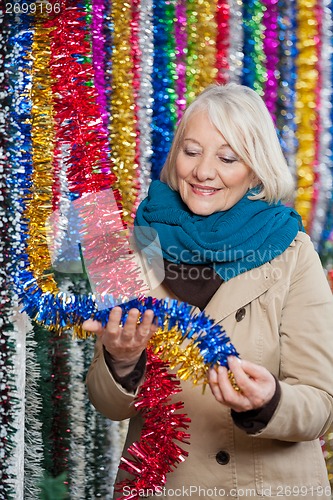 Image of Woman Choosing Tinsels At Christmas Store