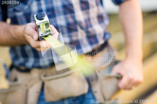 Image of Cropped Image Of Carpenter Holding Tape Measure