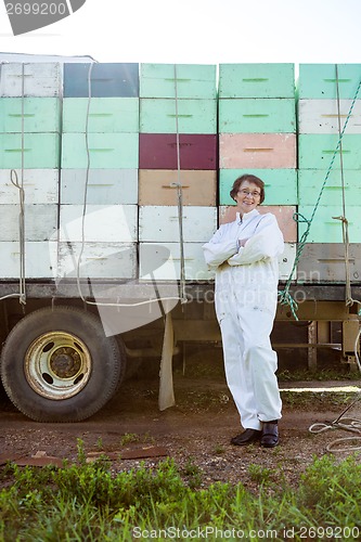 Image of Beekeeper Standing Against Truck Loaded With Crates