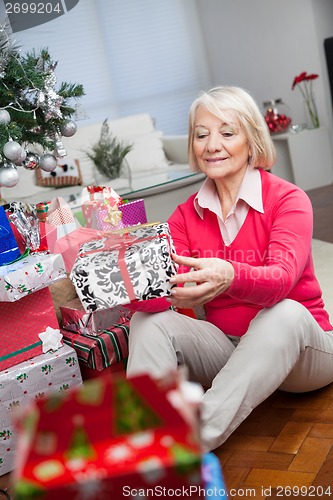 Image of Senior Woman Looking At Christmas Gift