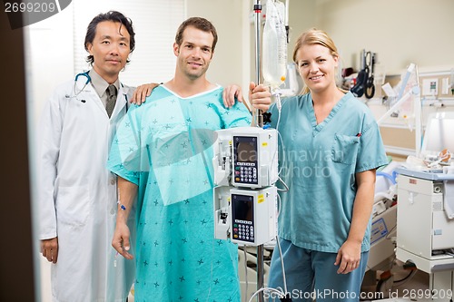 Image of Patient With Doctor And Nurse Standing By Machine Stand