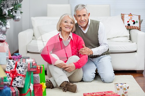 Image of Happy Senior Couple Sitting By Christmas Presents