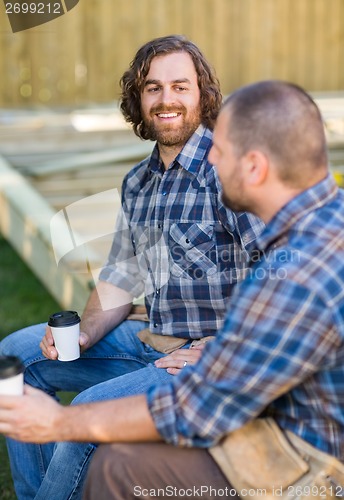 Image of Worker Holding Disposable Cup While Looking At Coworker