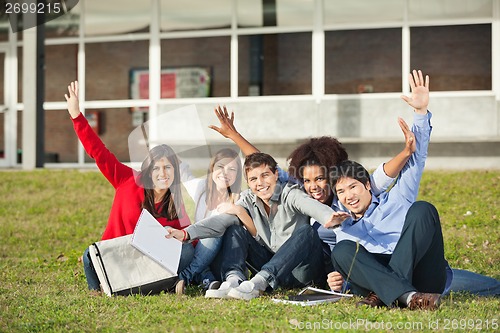 Image of Students With Hands Raised Sitting At University Campus
