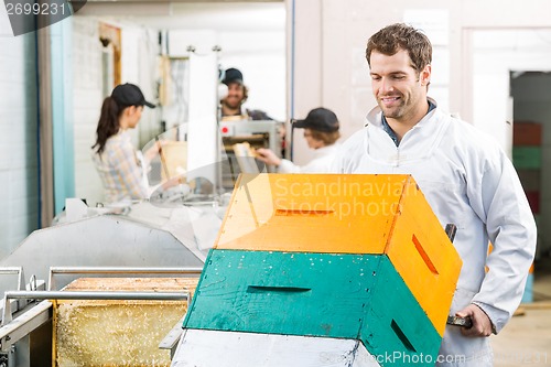 Image of Male Beekeeper Holding Trolley Of Stacked Honeycomb Crates