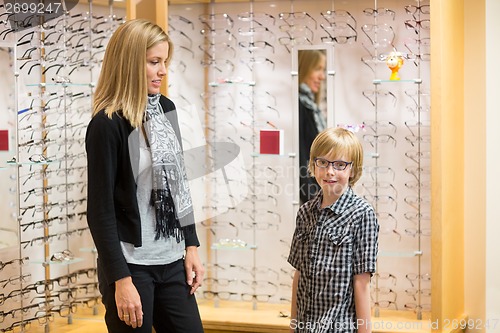 Image of Boy Wearing Spectacles While Mother Looking At Him In Shop