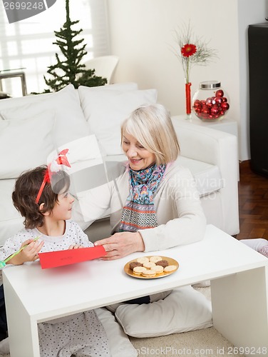 Image of Woman Assisting Boy In Making Christmas Greeting Card