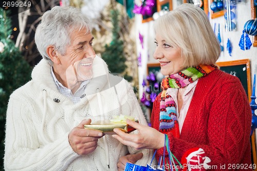 Image of Couple Holding Christmas Gift At Store